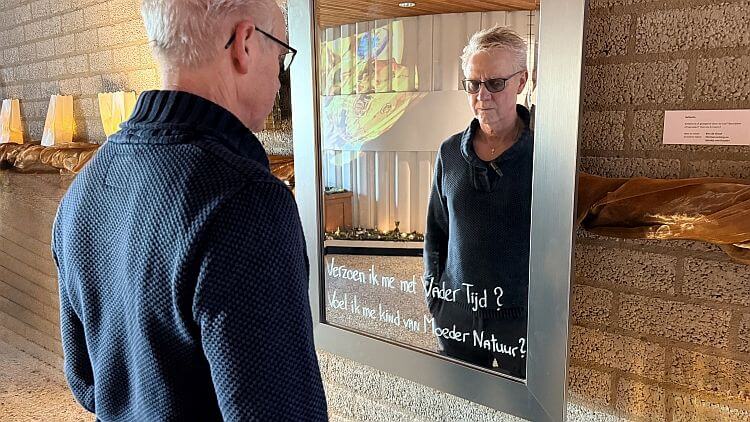 Ben staat op de Stiltedag in De Eshof voor zijn eigen spiegel en 'reflecteert' op zijn eigen tekst in de spiegel.