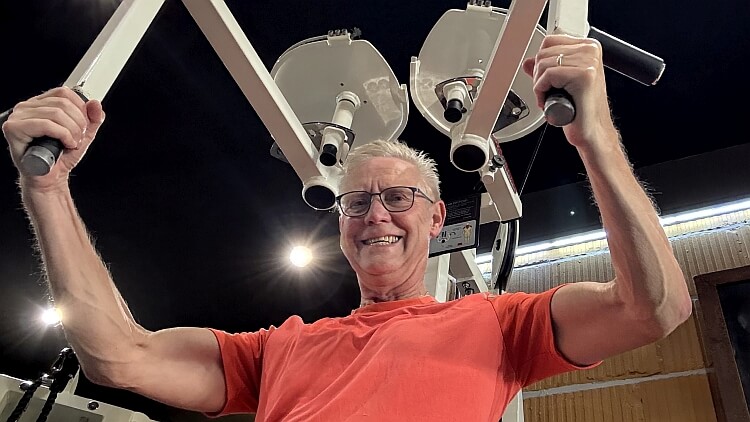 Ben oefent in de sportschool zijn borstspieren aan de pec fly